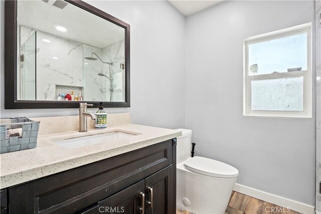 13118 Hoyt St, Pacoima, CA 91331 - bathroom with baseboards, a marble finish shower, toilet, wood finished floors, and vanity