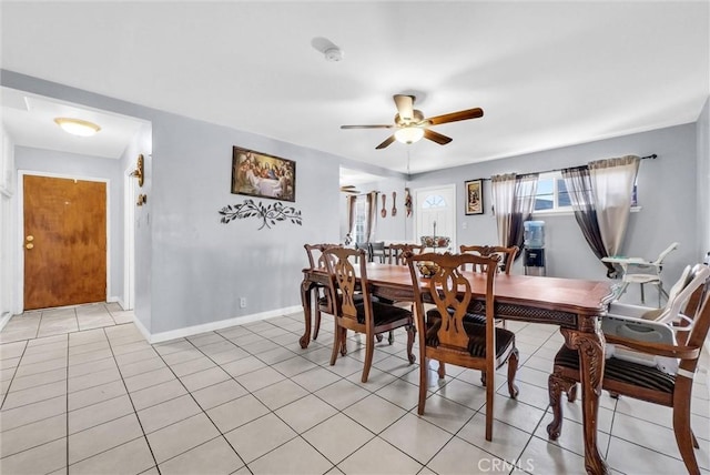 dining space featuring ceiling fan, baseboards, and light tile patterned floors