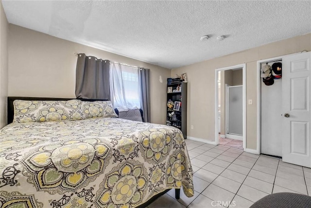 bedroom featuring baseboards, light tile patterned flooring, and a textured ceiling
