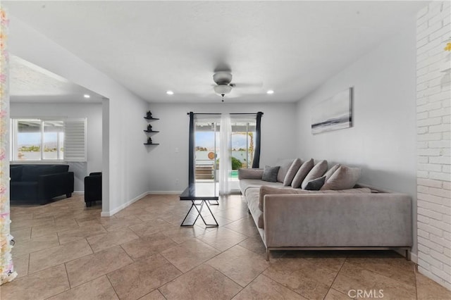 living area with baseboards, a healthy amount of sunlight, and recessed lighting