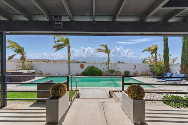 view of swimming pool with a patio, a water view, a jacuzzi, and a fenced in pool