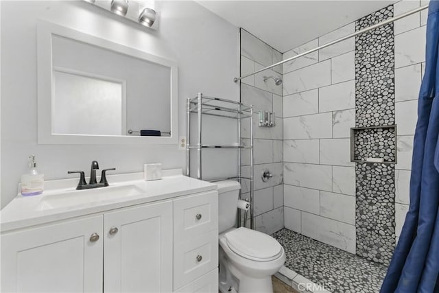 full bathroom with toilet, vanity, and a stall shower