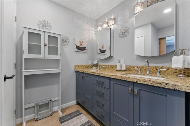 bathroom featuring double vanity, baseboards, and a sink