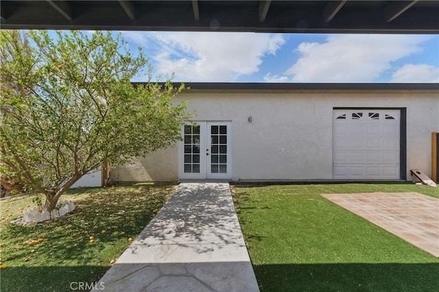doorway to property with stucco siding, a lawn, and french doors