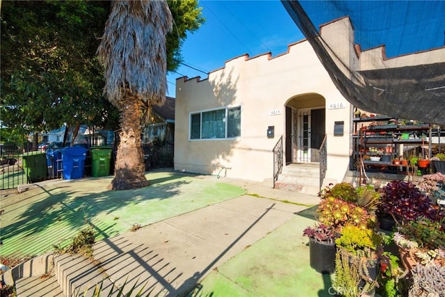view of front of house with fence and stucco siding