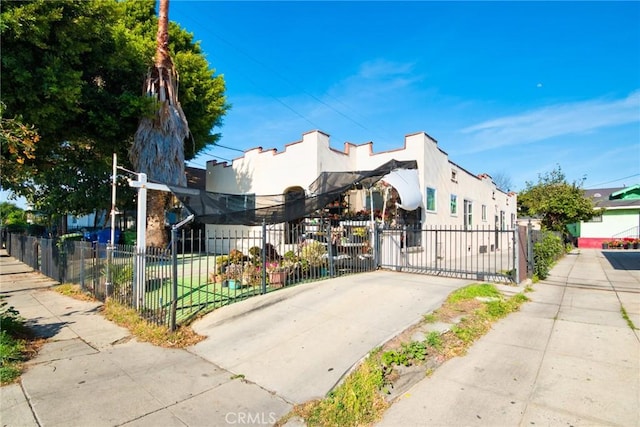 exterior space with stucco siding, fence, and a gate