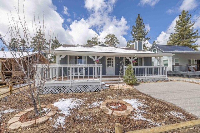 1066 Paradise Way, Big Bear City, CA 92314 - view of front of home featuring covered porch, concrete driveway, and a chimney