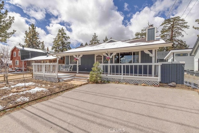 1066 Paradise Way, Big Bear City, CA 92314 - view of front facade with a chimney, a porch, and board and batten siding
