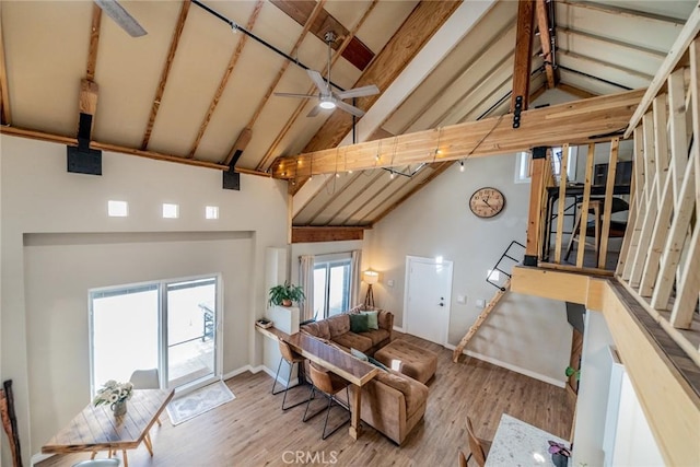 living area with high vaulted ceiling, beamed ceiling, a ceiling fan, and wood finished floors