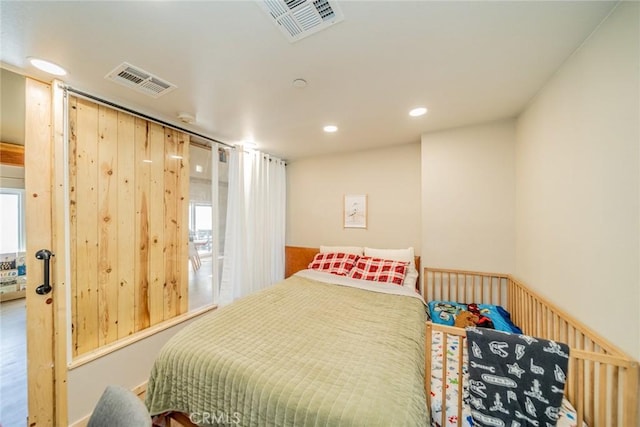 bedroom with recessed lighting, wooden walls, and visible vents