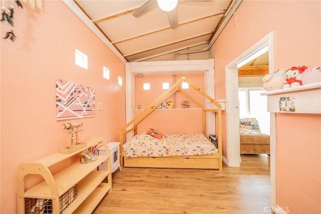 bedroom with vaulted ceiling and wood finished floors
