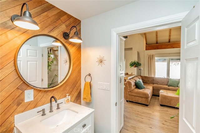 bathroom featuring wood finished floors, wooden walls, and vanity