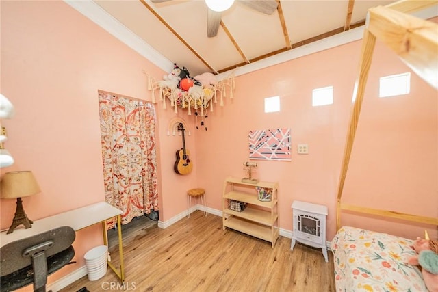 interior space featuring wood finished floors, baseboards, a ceiling fan, and heating unit