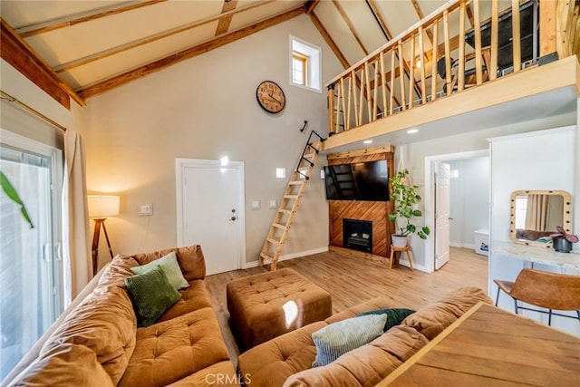 living area featuring high vaulted ceiling, a large fireplace, wood finished floors, baseboards, and beam ceiling