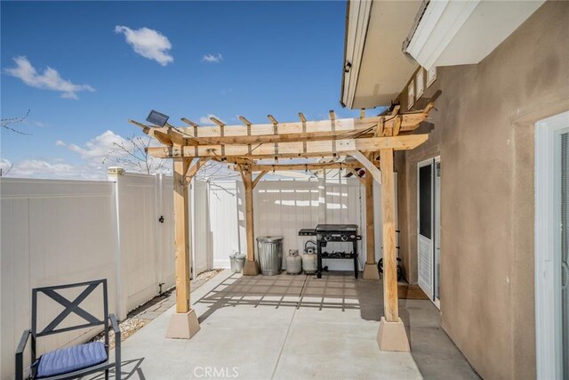 view of patio with a pergola, grilling area, and fence