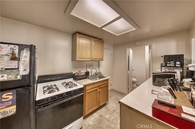 3611 4th Ave, La Crescenta, CA 91214 - kitchen with range with gas stovetop, freestanding refrigerator, a sink, and light countertops