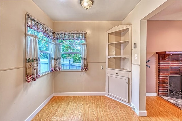 3611 4th Ave, La Crescenta, CA 91214 - unfurnished dining area featuring light wood-style flooring, a brick fireplace, and baseboards