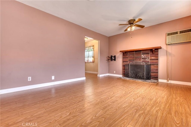 3611 4th Ave, La Crescenta, CA 91214 - unfurnished living room featuring a wall mounted air conditioner, a ceiling fan, wood finished floors, a fireplace, and baseboards
