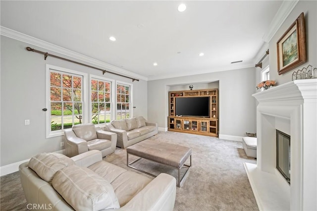 carpeted living area featuring a glass covered fireplace, crown molding, and baseboards