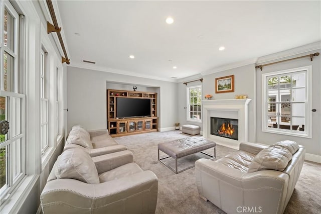 living area featuring recessed lighting, ornamental molding, baseboards, a glass covered fireplace, and carpet flooring