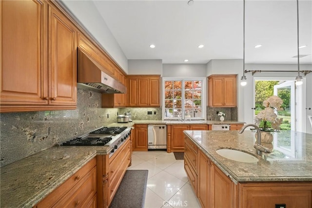 kitchen featuring wall chimney range hood, a sink, decorative backsplash, light tile patterned floors, and appliances with stainless steel finishes