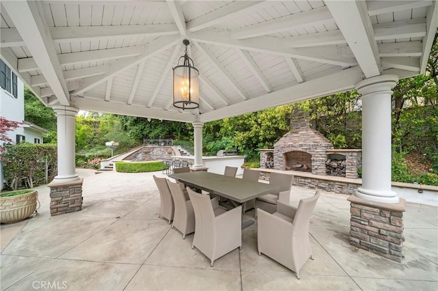 view of patio featuring a gazebo, an outdoor stone fireplace, and outdoor dining space