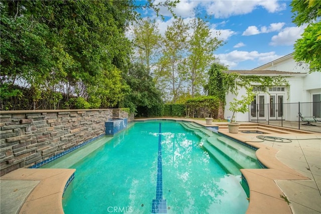view of swimming pool featuring a fenced backyard, a patio, a fenced in pool, and french doors