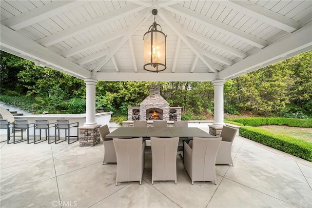 view of patio featuring outdoor dry bar, a gazebo, and an outdoor stone fireplace