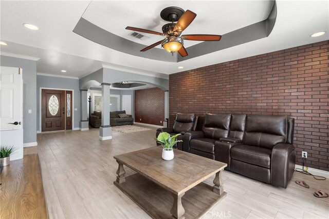 14445 Dove Canyon Dr, Riverside, CA 92503 - living room featuring ornate columns, arched walkways, brick wall, ceiling fan, and baseboards