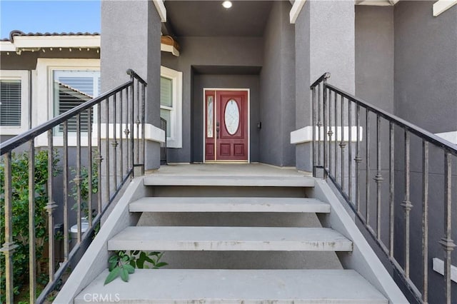 entrance to property featuring stucco siding