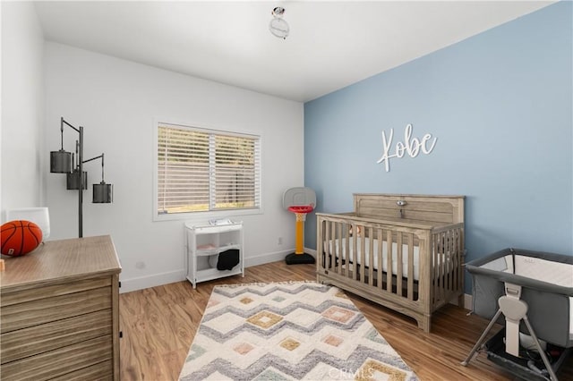 14445 Dove Canyon Dr, Riverside, CA 92503 - bedroom with wood finished floors, baseboards, and a nursery area