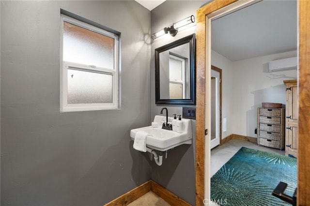 bathroom with baseboards and a wall mounted AC