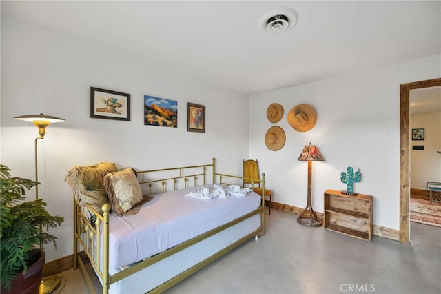 bedroom featuring finished concrete flooring, baseboards, and visible vents