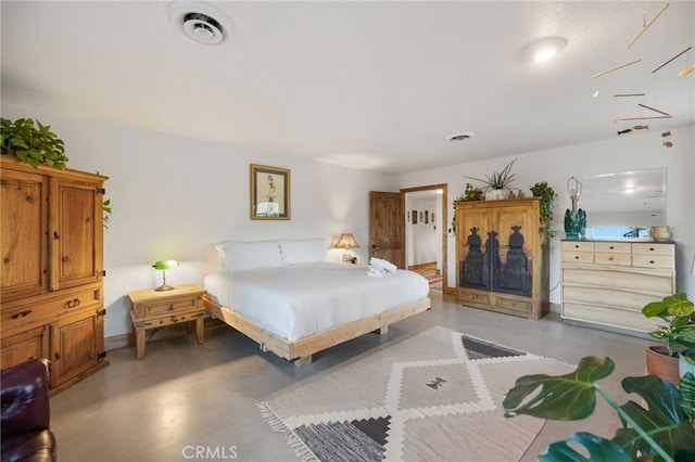 bedroom featuring finished concrete flooring and visible vents