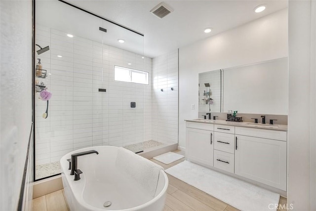 27824 Marquee Dr, Valencia, CA 91381 - full bath featuring a shower stall, a freestanding bath, double vanity, wood finished floors, and recessed lighting