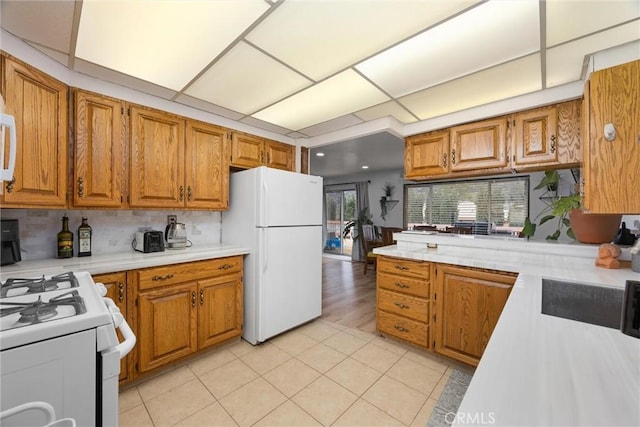 4228 Willow Trl, Frazier Park, CA 93225 - kitchen with white appliances, light countertops, brown cabinets, and backsplash