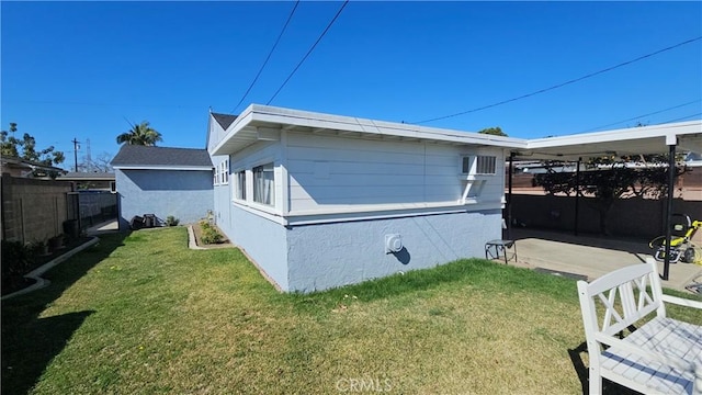 view of side of property with a lawn and fence