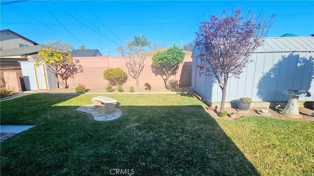 view of yard featuring an outbuilding, fence private yard, and a shed