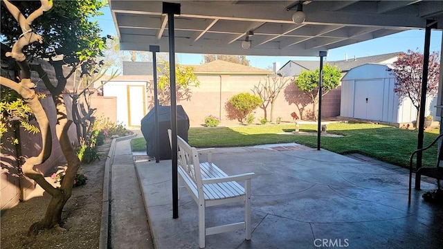 view of patio featuring fence, an outbuilding, and a storage shed
