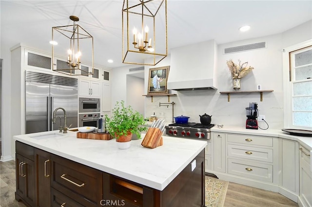 29528 Ridgeway Dr, Agoura Hills, CA 91301 - kitchen featuring premium range hood, appliances with stainless steel finishes, a sink, a chandelier, and white cabinets