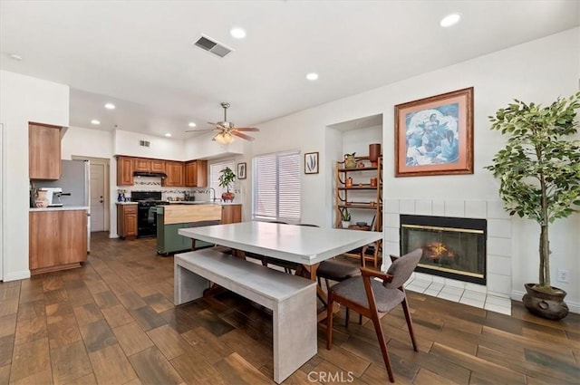 2583 W Fairview Dr, Rialto, CA 92377 - dining room with a fireplace, dark wood finished floors, a ceiling fan, visible vents, and recessed lighting