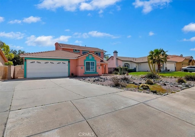 2583 W Fairview Dr, Rialto, CA 92377 - view of front of home featuring stucco siding, driveway, an attached garage, a tiled roof, and fence