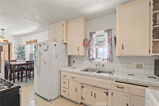 300 Palisade St, Pasadena, CA 91103 - kitchen featuring white refrigerator with ice dispenser, tile counters, black range with gas cooktop, and hanging light fixtures