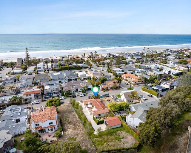 drone / aerial view featuring a residential view, a view of the beach, and a water view