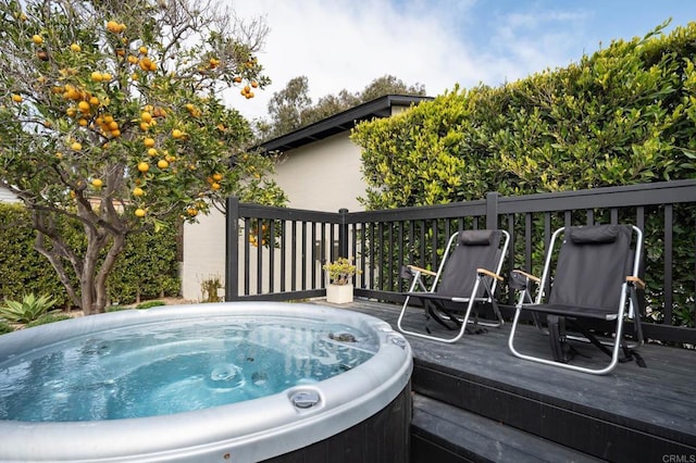 deck with an outdoor hot tub