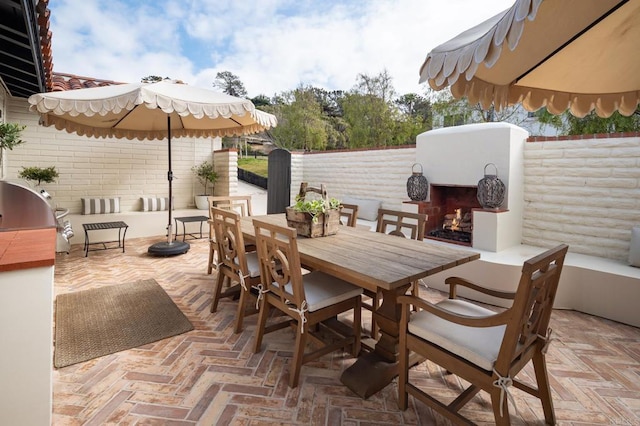 view of patio with an outdoor fireplace, grilling area, fence private yard, and outdoor dining area