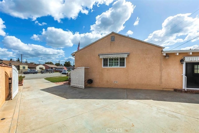 back of house with stucco siding and a patio
