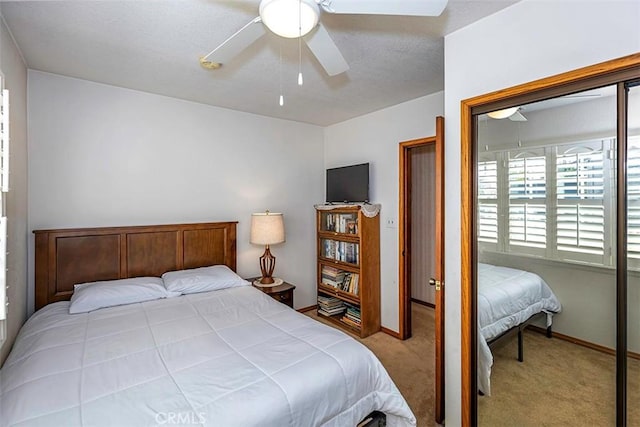 bedroom featuring baseboards, a ceiling fan, a closet, and carpet
