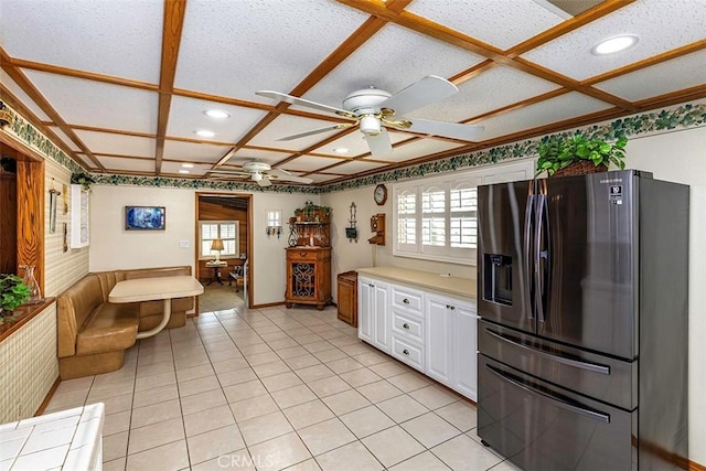 kitchen with stainless steel fridge with ice dispenser, ceiling fan, a healthy amount of sunlight, and white cabinets