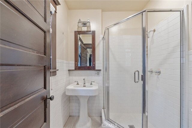 2280 W 24th St, Los Angeles, CA 90018 - bathroom featuring a wainscoted wall, tile walls, and a shower stall